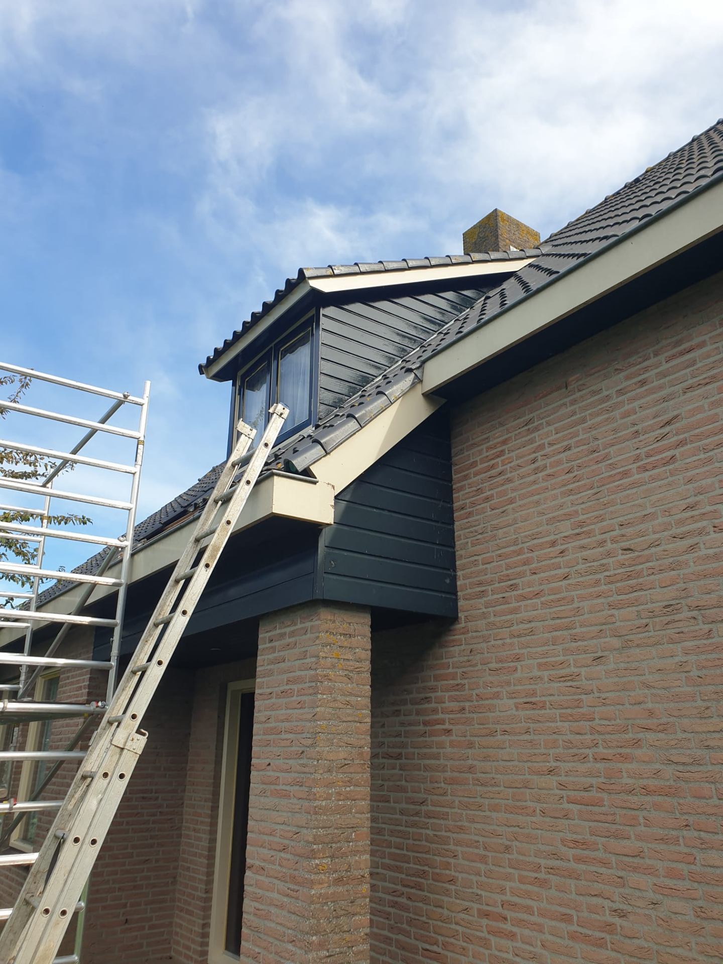Schilderwerk op hoogte aan Nederlandse woning met steiger en ladder