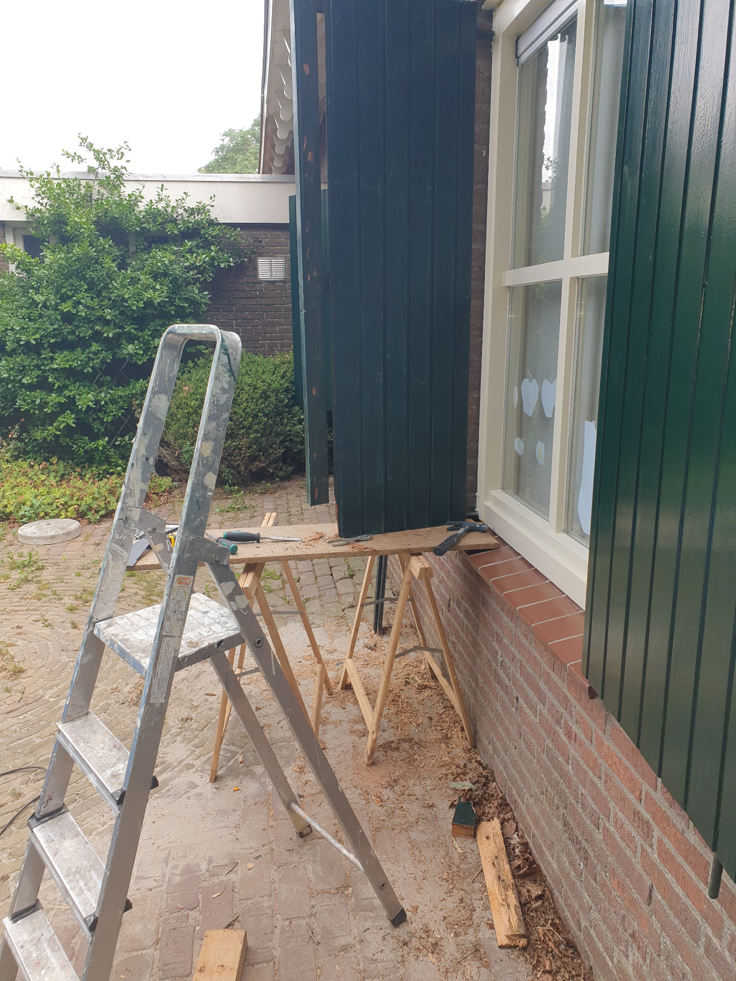 Raamluik voor herstel — rotte delen zichtbaar