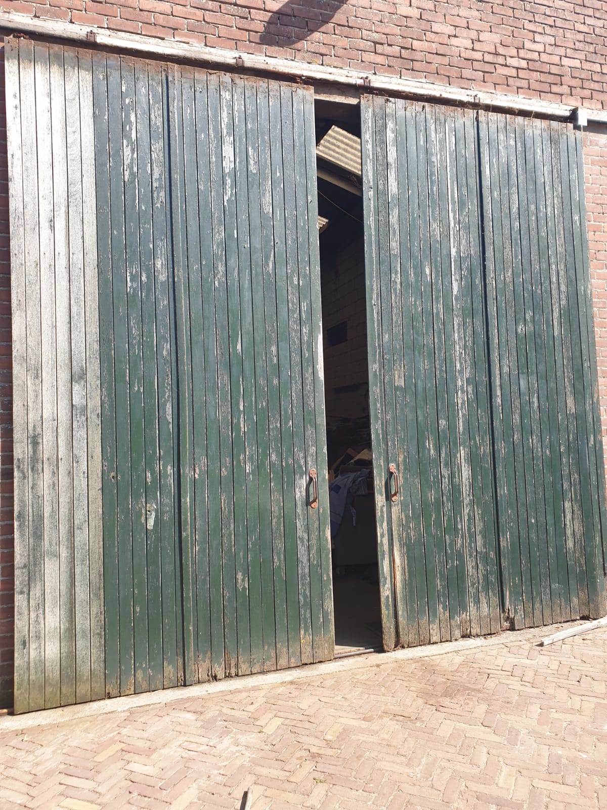 Staldeuren van een boerderij vóór het schilderwerk — verweerd en afbladderend